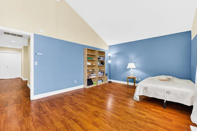a bedroom with a bed and wooden floor