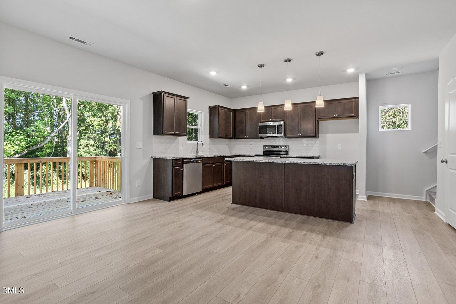 248 Alice Trace Place Angier, NC 27501 - Photo 4 of 32 a kitchen with stainless steel appliances granite countertop a refrigerator and a stove top oven