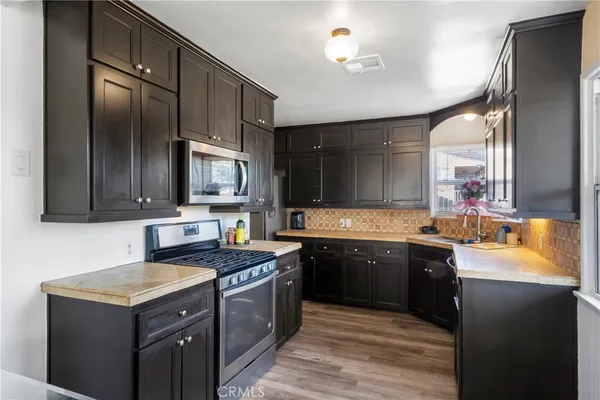 a kitchen with stainless steel appliances granite countertop a sink stove and refrigerator