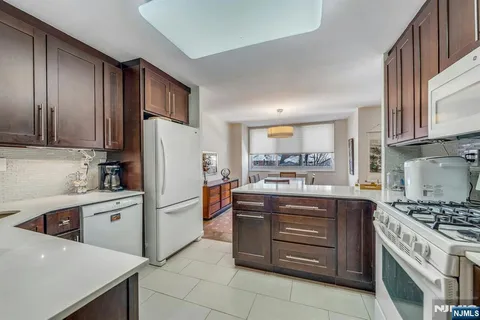 a kitchen with stainless steel appliances a stove a sink and a refrigerator with wooden cabinets