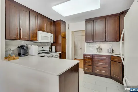 a kitchen with granite countertop wooden cabinets and stainless steel appliances