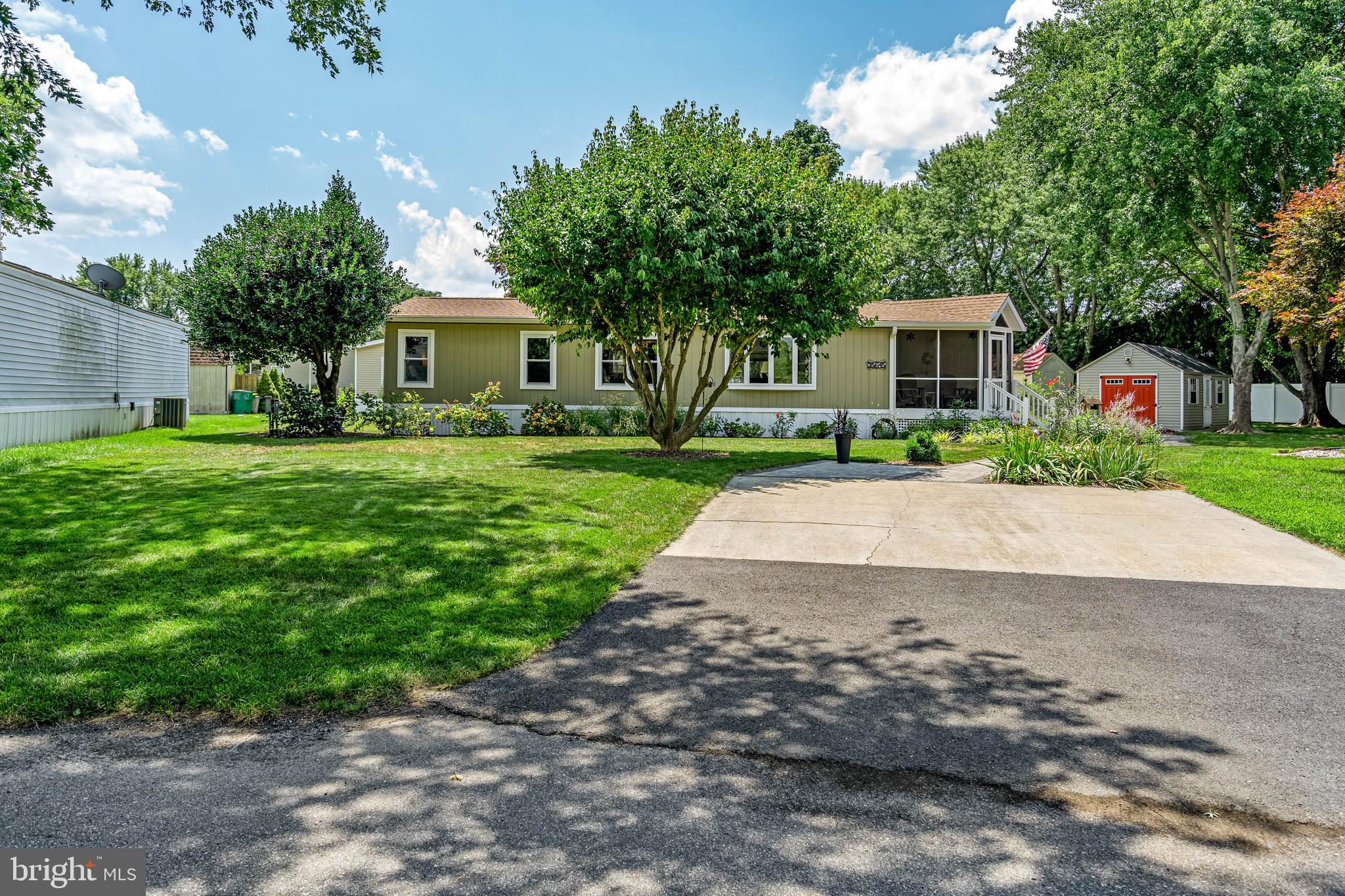 35645 Elk Camp Road Rehoboth Beach, DE 19971 - Photo 1 of 59 a front view of a house with a garden and trees