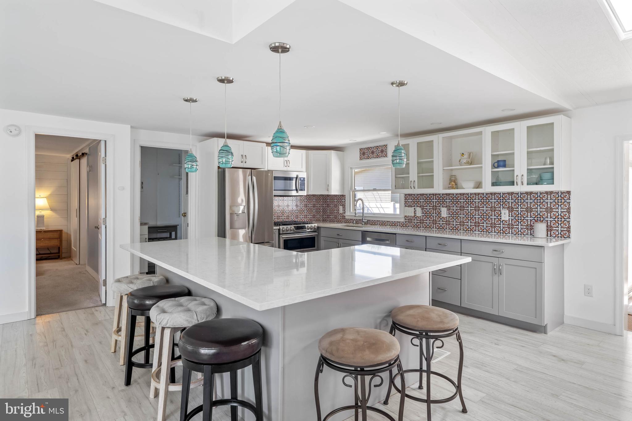 35645 Elk Camp Road Rehoboth Beach, DE 19971 - Photo 20 of 59 a kitchen with granite countertop a table chairs stove and refrigerator