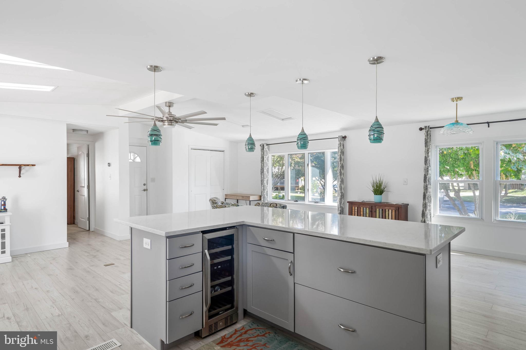 35645 Elk Camp Road Rehoboth Beach, DE 19971 - Photo 23 of 59 a kitchen with a sink dishwasher a stove and white cabinets with wooden floor