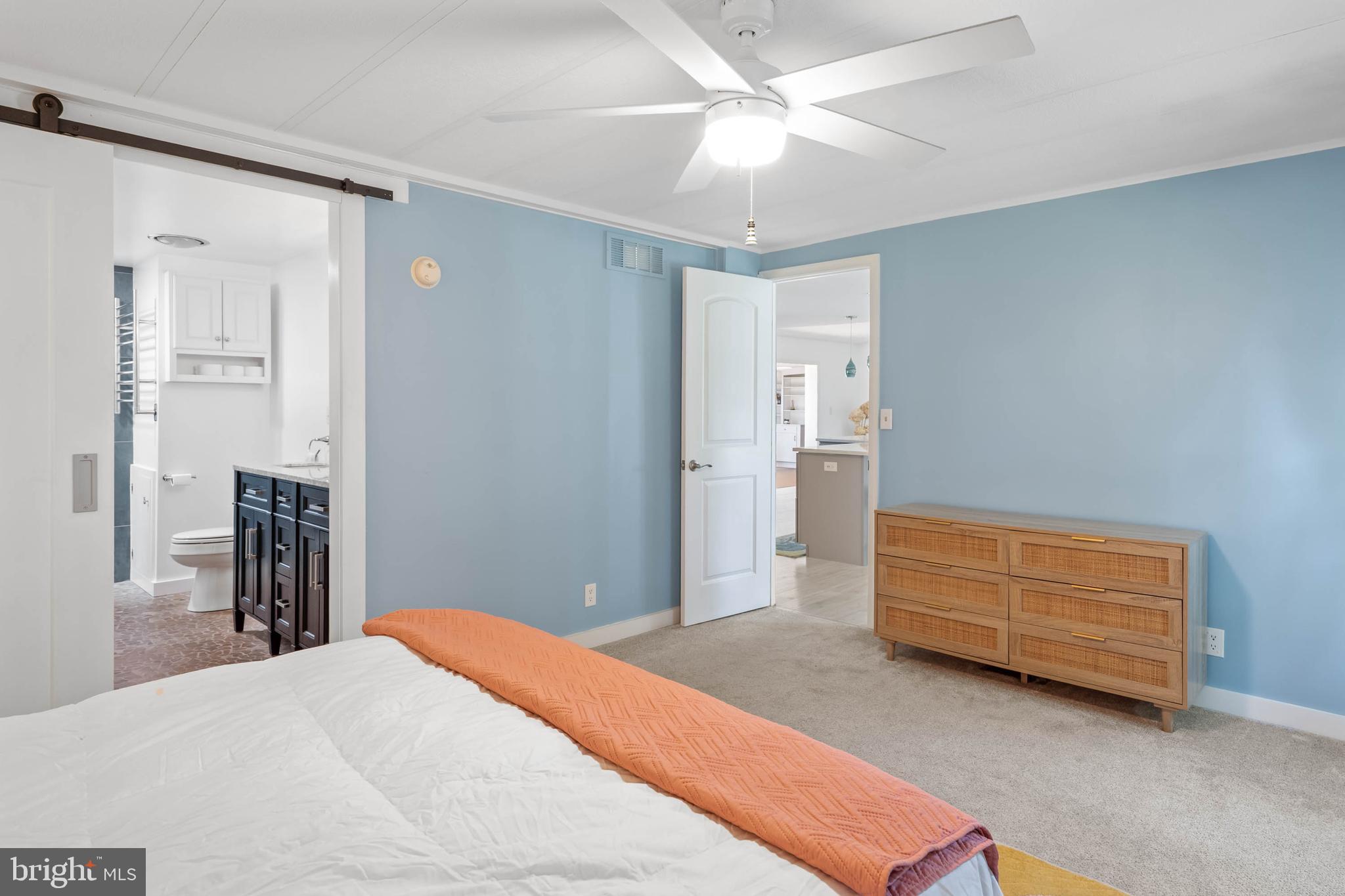 35645 Elk Camp Road Rehoboth Beach, DE 19971 - Photo 26 of 59 a bedroom with a bed and a chandelier