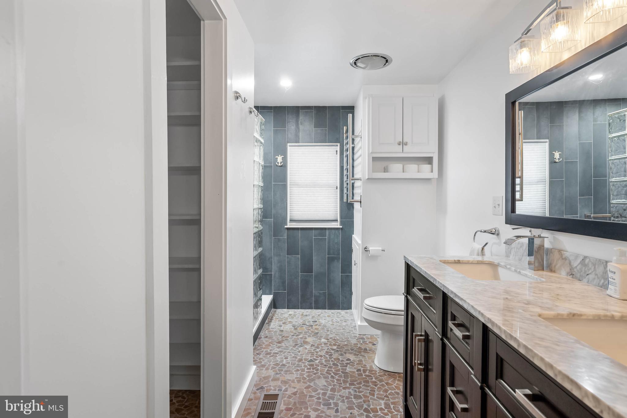35645 Elk Camp Road Rehoboth Beach, DE 19971 - Photo 31 of 59 a bathroom with a granite countertop sink a toilet and shower