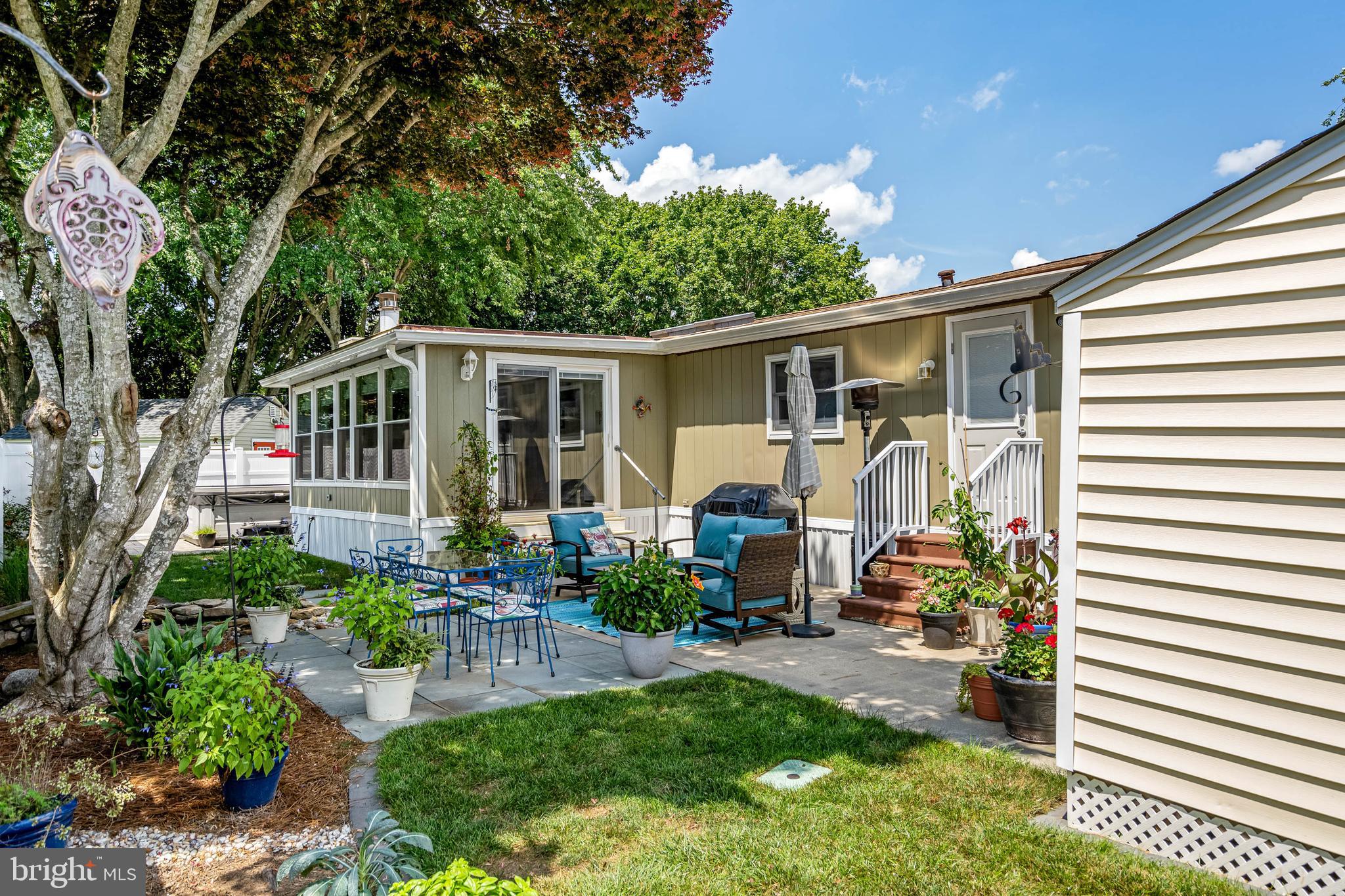 35645 Elk Camp Road Rehoboth Beach, DE 19971 - Photo 7 of 59 a view of a patio with chair and tables back yard of the house