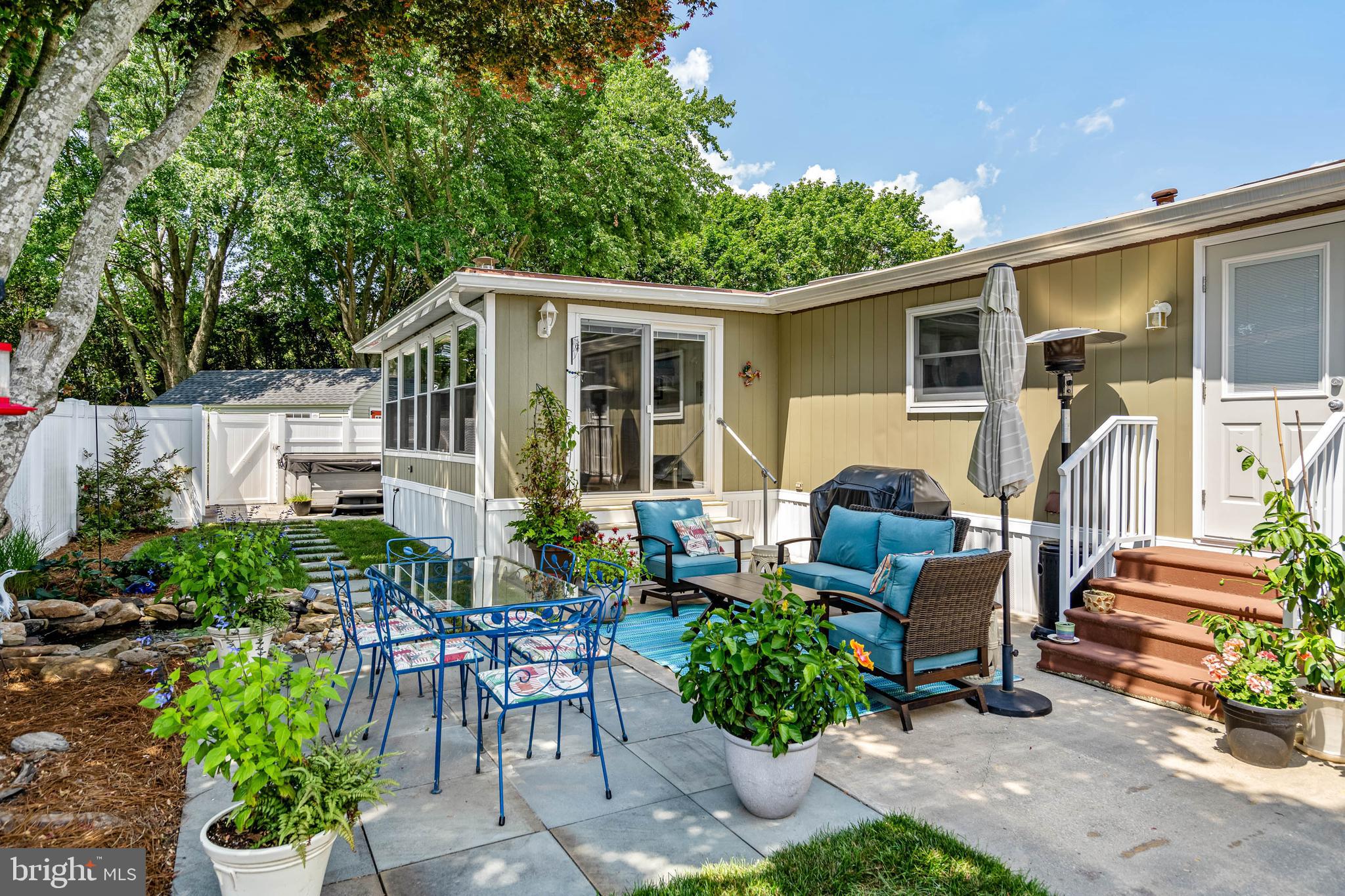 35645 Elk Camp Road Rehoboth Beach, DE 19971 - Photo 9 of 59 a view of a patio with table and chairs potted plants and large tree