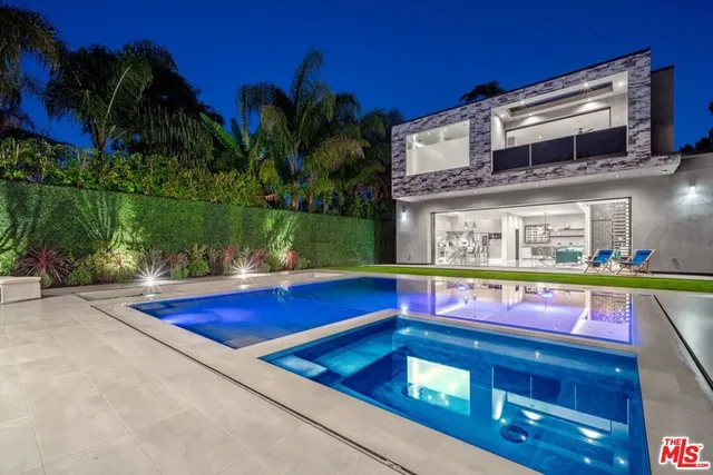 a view of swimming pool with a yard chairs and palm tree