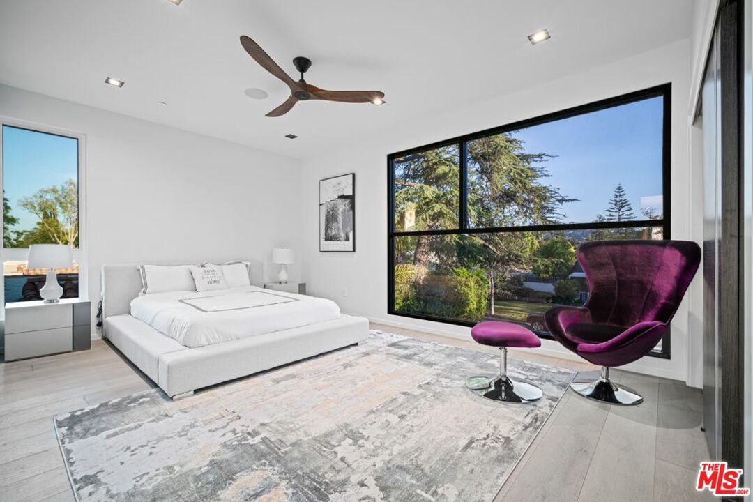 11241 Blix Street Toluca Lake, CA 91602 - Photo 13 of 19 a bedroom with a large bed and a large window