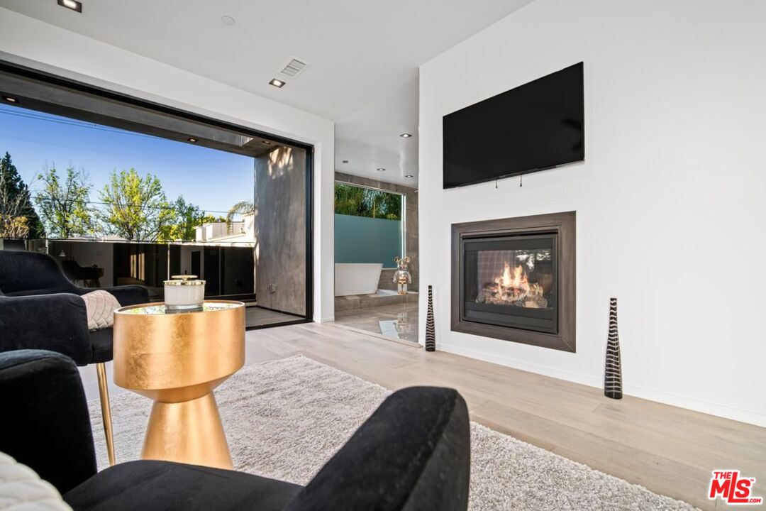 11241 Blix Street Toluca Lake, CA 91602 - Photo 17 of 19 a living room with furniture a flat screen tv and a fireplace