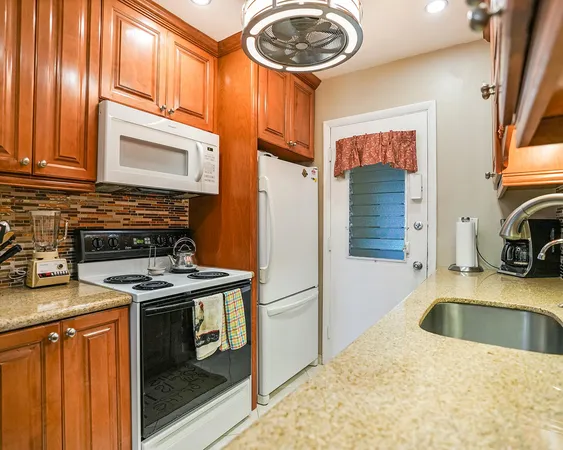 a kitchen with stainless steel appliances granite countertop a stove a sink and a refrigerator