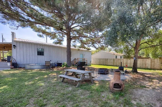 a view of a backyard with table and chairs and a fire pit