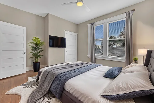 a bedroom with a bed and a potted plant
