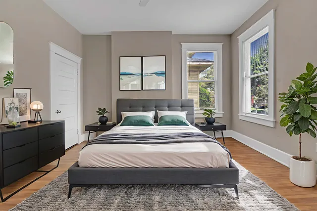a bedroom with a large bed and wooden floor