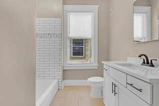 a bathroom with a granite countertop sink toilet a mirror and shower