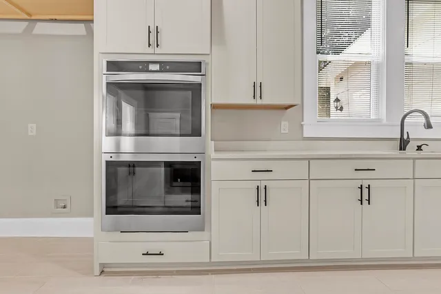 a kitchen with granite countertop white cabinets and white appliances