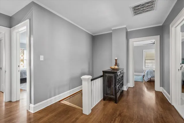 a hallway with wooden floor windows and closet