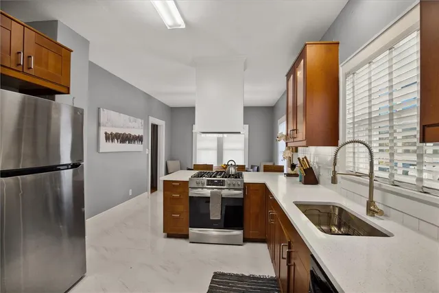 a kitchen with a stove a refrigerator and a sink