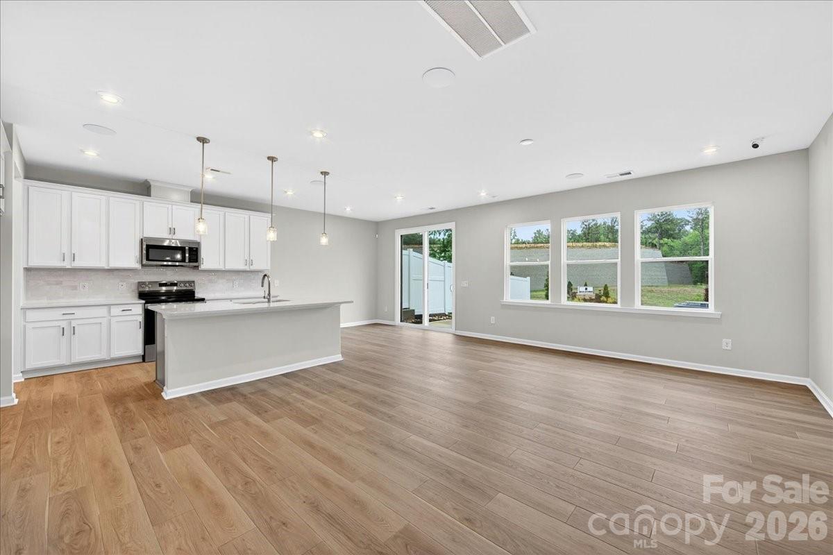 512 Webster Lane Cramerton, NC 28032 - Photo 11 of 28 a large kitchen with stainless steel appliances granite countertop a stove a sink dishwasher and a large refrigerator with wooden floor