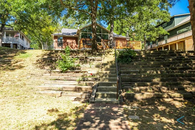 a view of a backyard with plants and wooden fence
