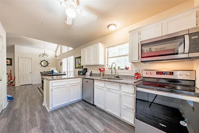 a kitchen with stainless steel appliances a stove a sink dishwasher and cabinets