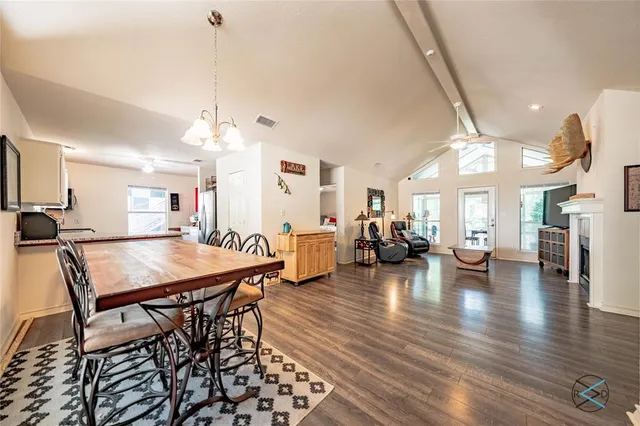 a view of a dining room and livingroom with furniture wooden floor a chandelier