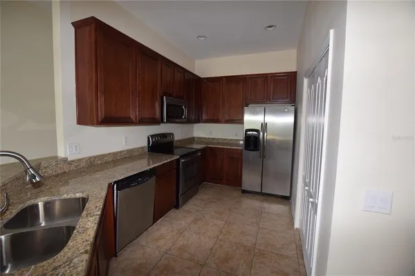 a kitchen with stainless steel appliances granite countertop a sink stove and refrigerator