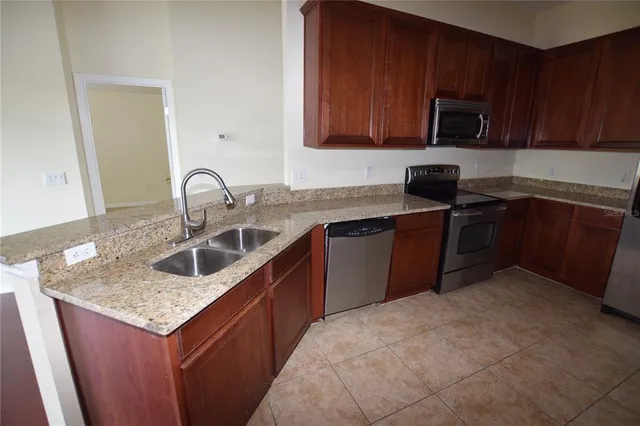 a kitchen with stainless steel appliances granite countertop a sink stove and microwave