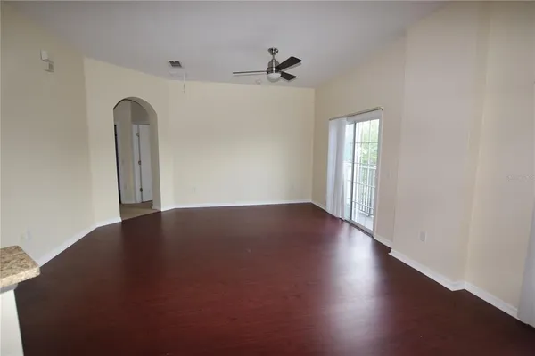 an empty room with wooden floor closet and windows