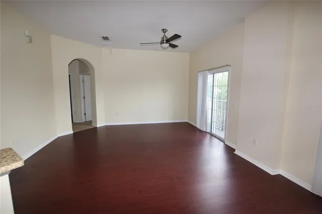 an empty room with wooden floor closet and windows