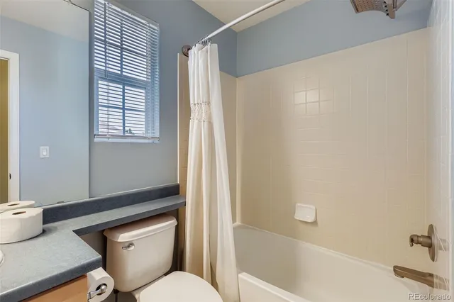 a white toilet sitting next to a bath tub