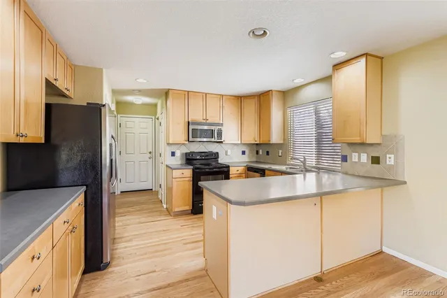a kitchen with a sink a counter top space stainless steel appliances and cabinets