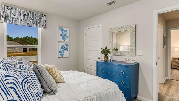 a bedroom with a bed and a potted plant