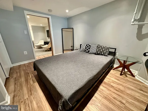 a bedroom with a bed and wooden floor