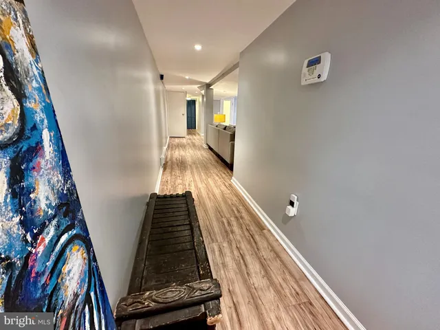 a view of a hallway with wooden floor and stairs