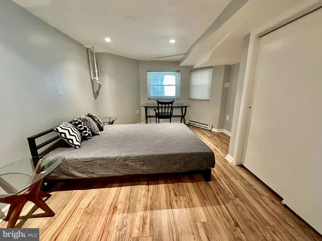 a bedroom with a bed and wooden floor