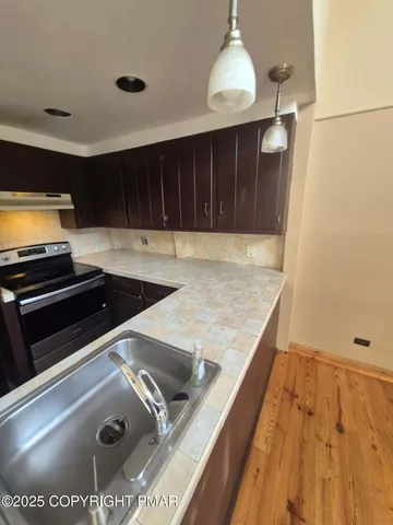 a kitchen with kitchen island a counter space a sink and a stove