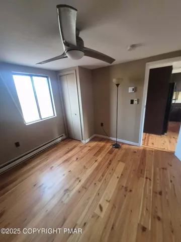 a view of a livingroom with wooden floor and a ceiling fan