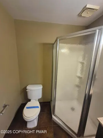 a bathroom with a toilet and a shower