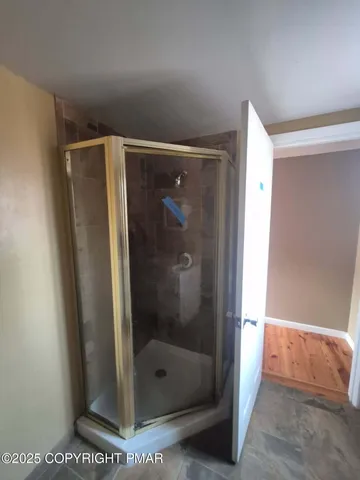 a bathroom with a glass shower door and a window
