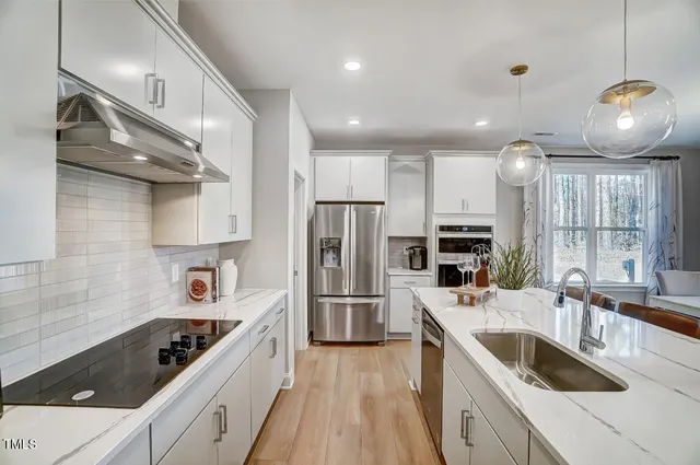 a kitchen with stainless steel appliances granite countertop a sink stove and refrigerator