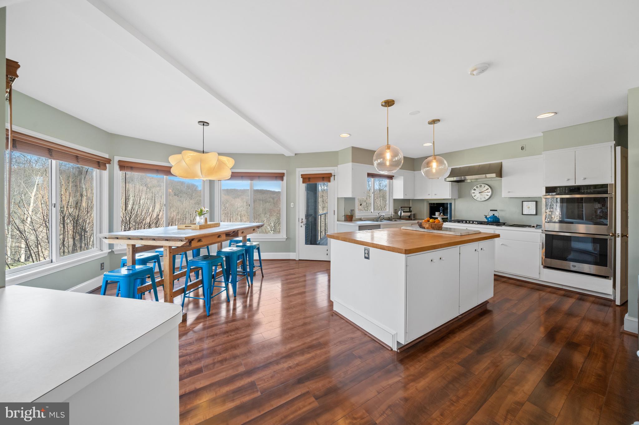 3930 Thompsons Bridge Road Wilmington, DE 19807 - Photo 17 of 69 a kitchen with stainless steel appliances kitchen island wooden floors and white cabinets