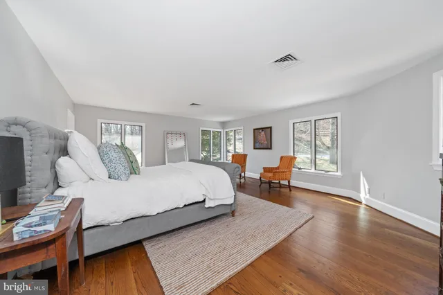 a view of a white house with a large pool and couches chairs