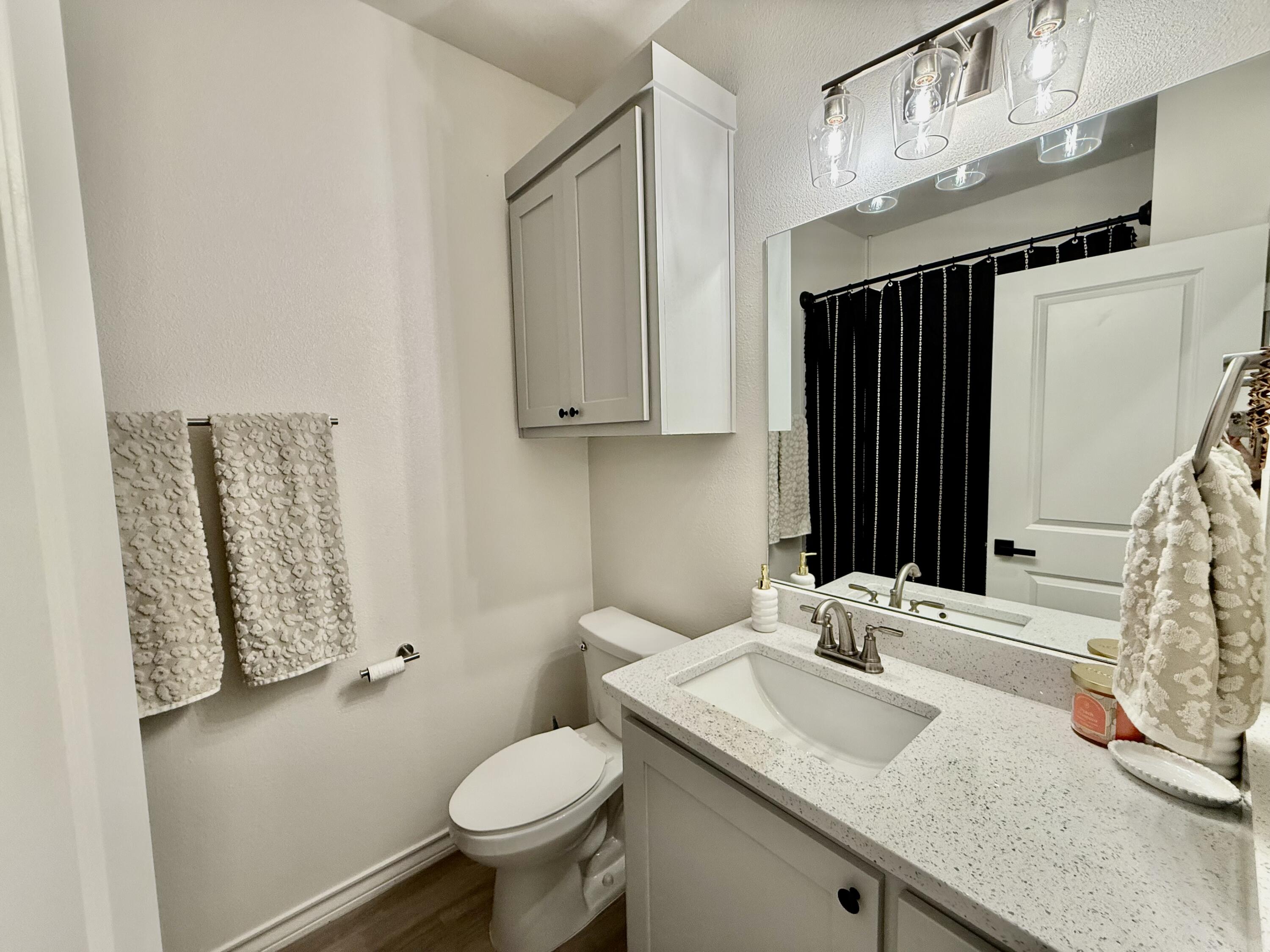 5833 Virginia Avenue Lubbock, TX 79407 - Photo 12 of 33 a bathroom with a granite countertop sink and a mirror