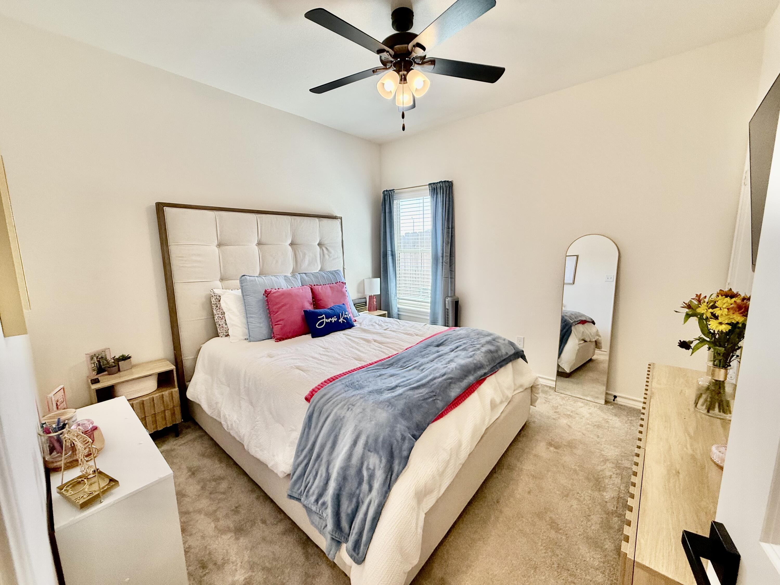 5833 Virginia Avenue Lubbock, TX 79407 - Photo 13 of 33 a bedroom with bed and a chandelier