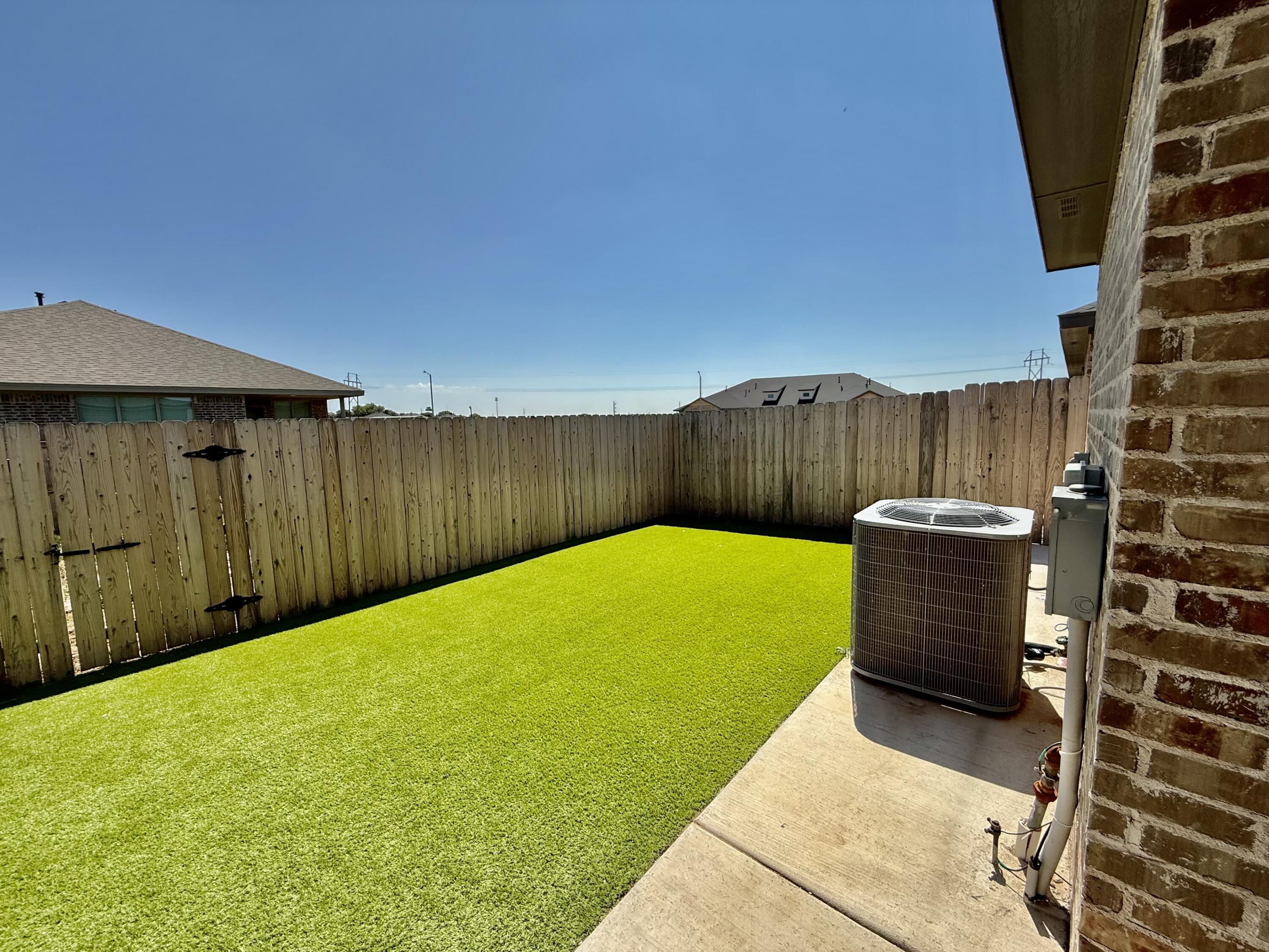 5833 Virginia Avenue Lubbock, TX 79407 - Photo 19 of 33 a view of a backyard with a wooden fence
