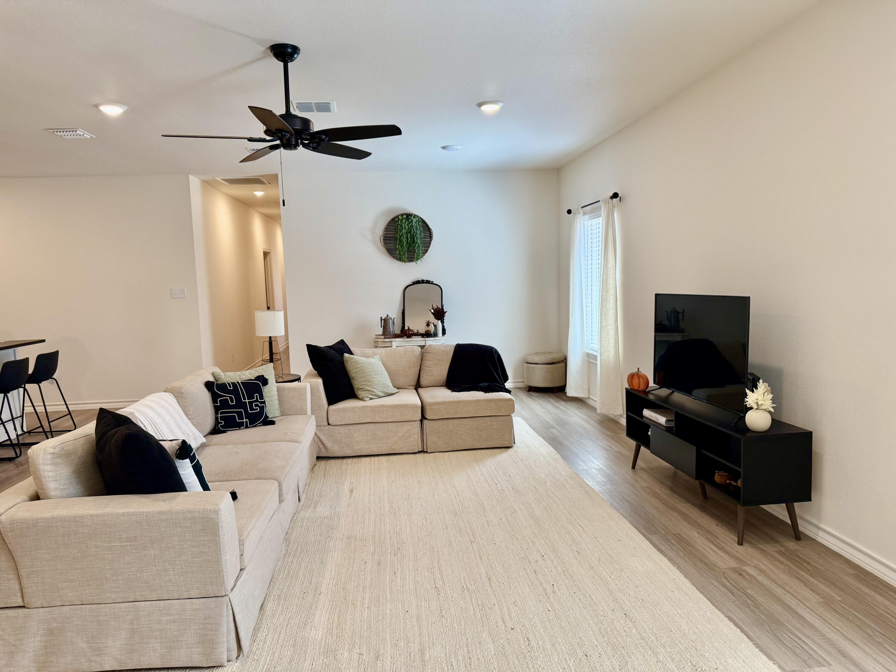 5833 Virginia Avenue Lubbock, TX 79407 - Photo 5 of 33 a living room with furniture a flat screen tv and a window