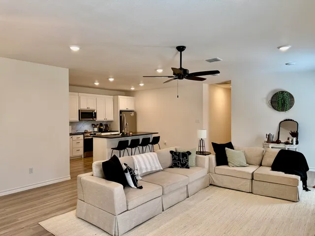 a living room with furniture and a ceiling fan