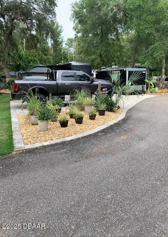 a view of a patio with chairs and potted plants